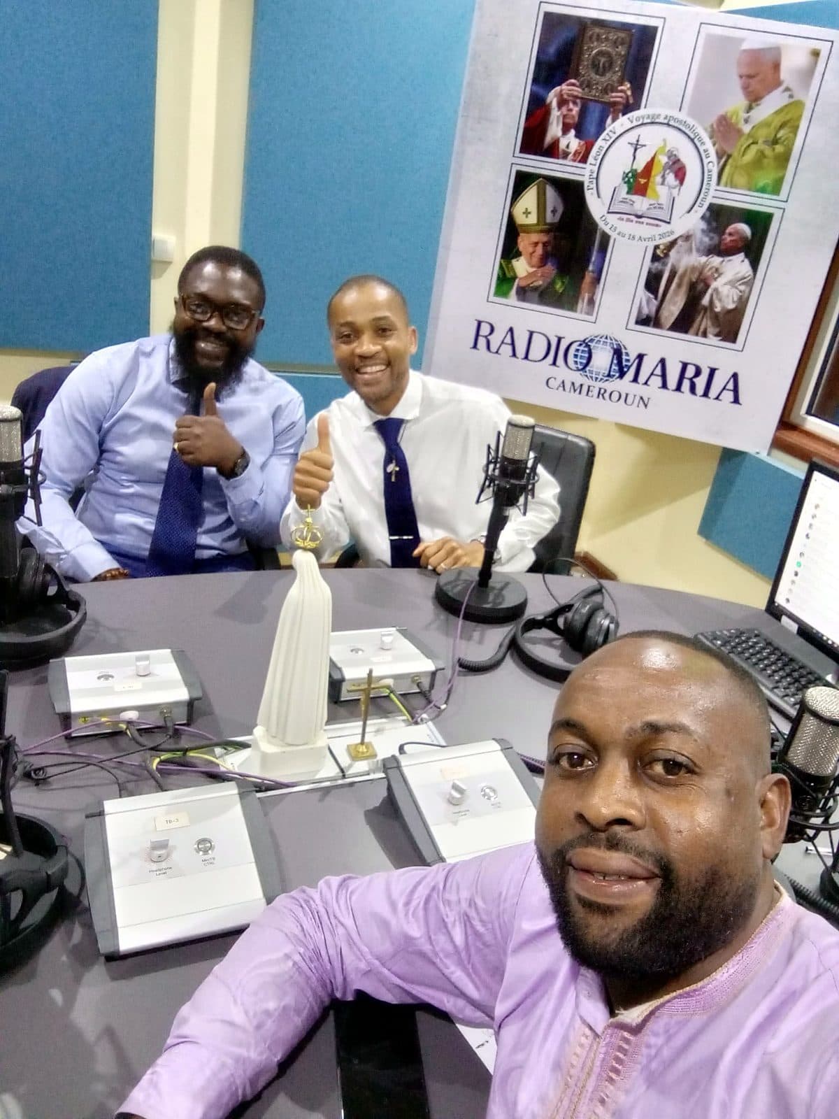 Selfie in the Radio Maria Cameroon studio, with two guests giving a thumbs up